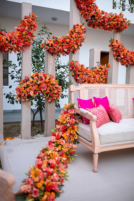 Pink seating framed by orange flowers
