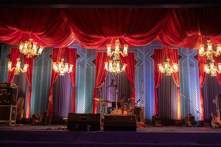 Red drapes and chandeliers for a sangeet evening
